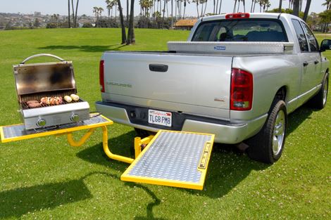 Truck with foldable tables attached to the back for tailgating.