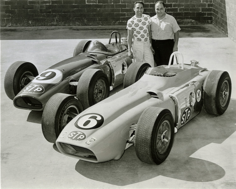 Andy Granatelli and his brother Vincent standing behind two race cars