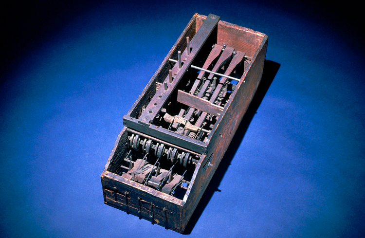 A rectangular wooden box holding gears and levers