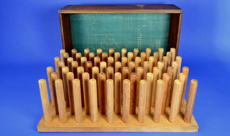 Wooden box with the lid off, showing 40 spindles and a blueprint lining the lid.