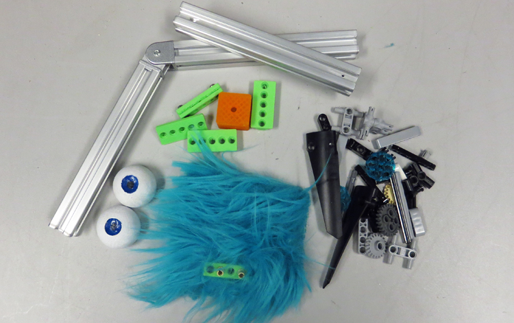 An array of parts from which a creature can be made; includes blue polyester fur, hinged aluminum rods, miscellaneous Lego bits and 3D-printed parts, and small balls made into eyes.