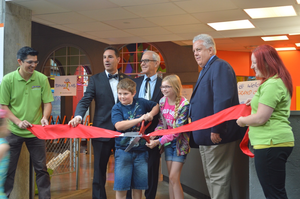 Director Art Molella cuts the ribbon to open Spark!Lab at Science City in Kansas City with representatives from the Museum and the Ford Motor Company Fund, as well as some local children.