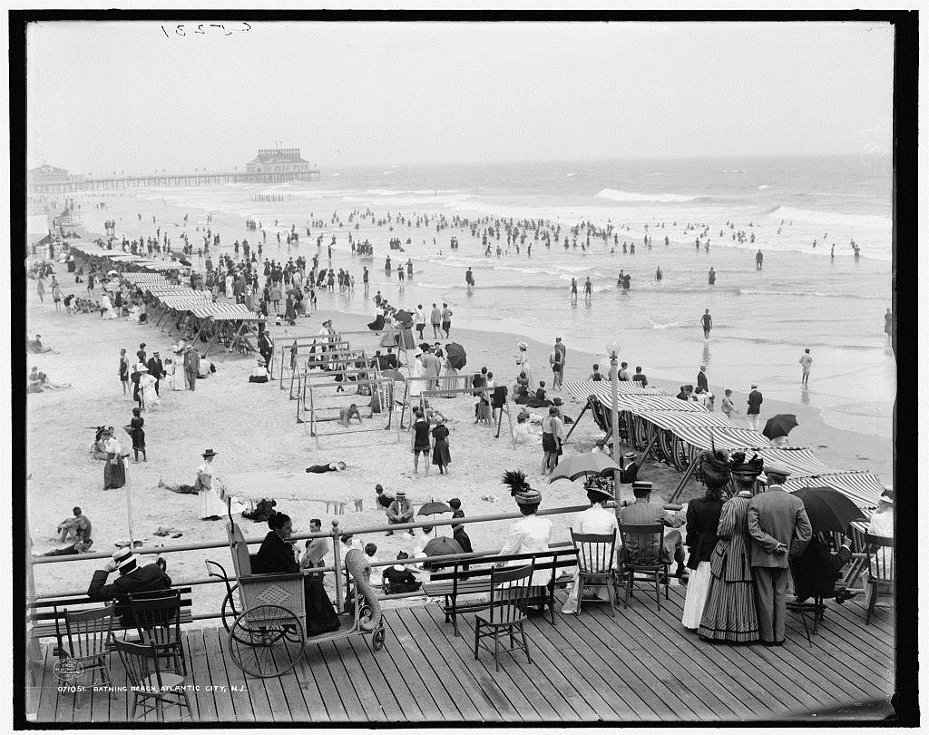 Black and white photo of crowds on the beach in Atlantic City, NJ, 1908.