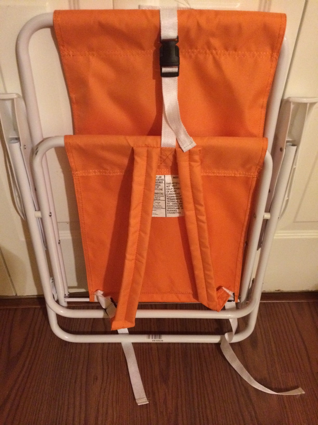 Orange and white beach chair that can be worn like a backpack.