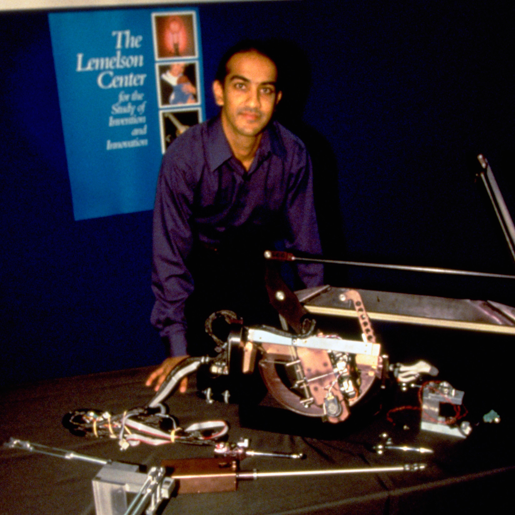Image of Akhil Madhani with some of his robot inventions