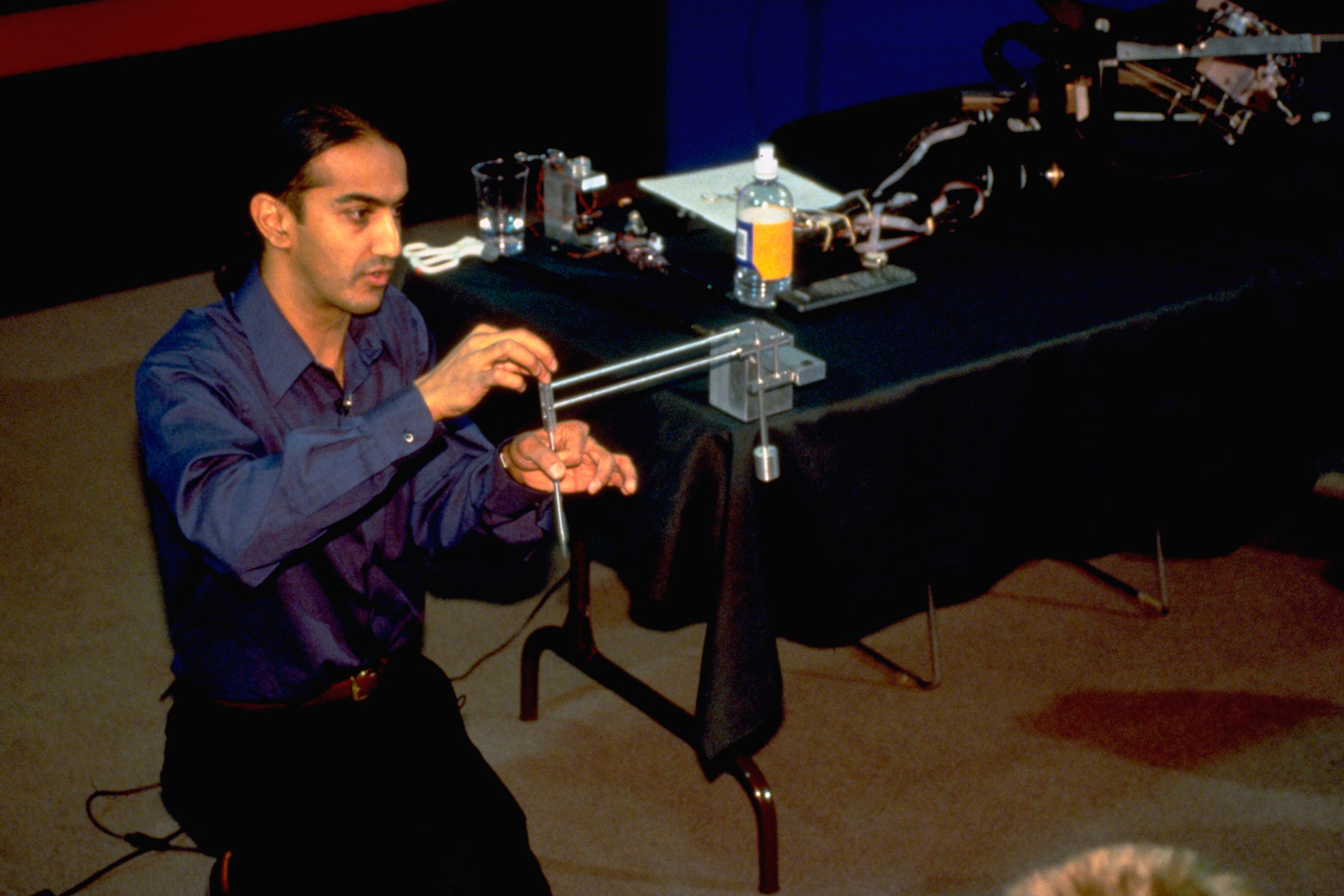 Image of Akhil Madhani demonstrating how robot arms work