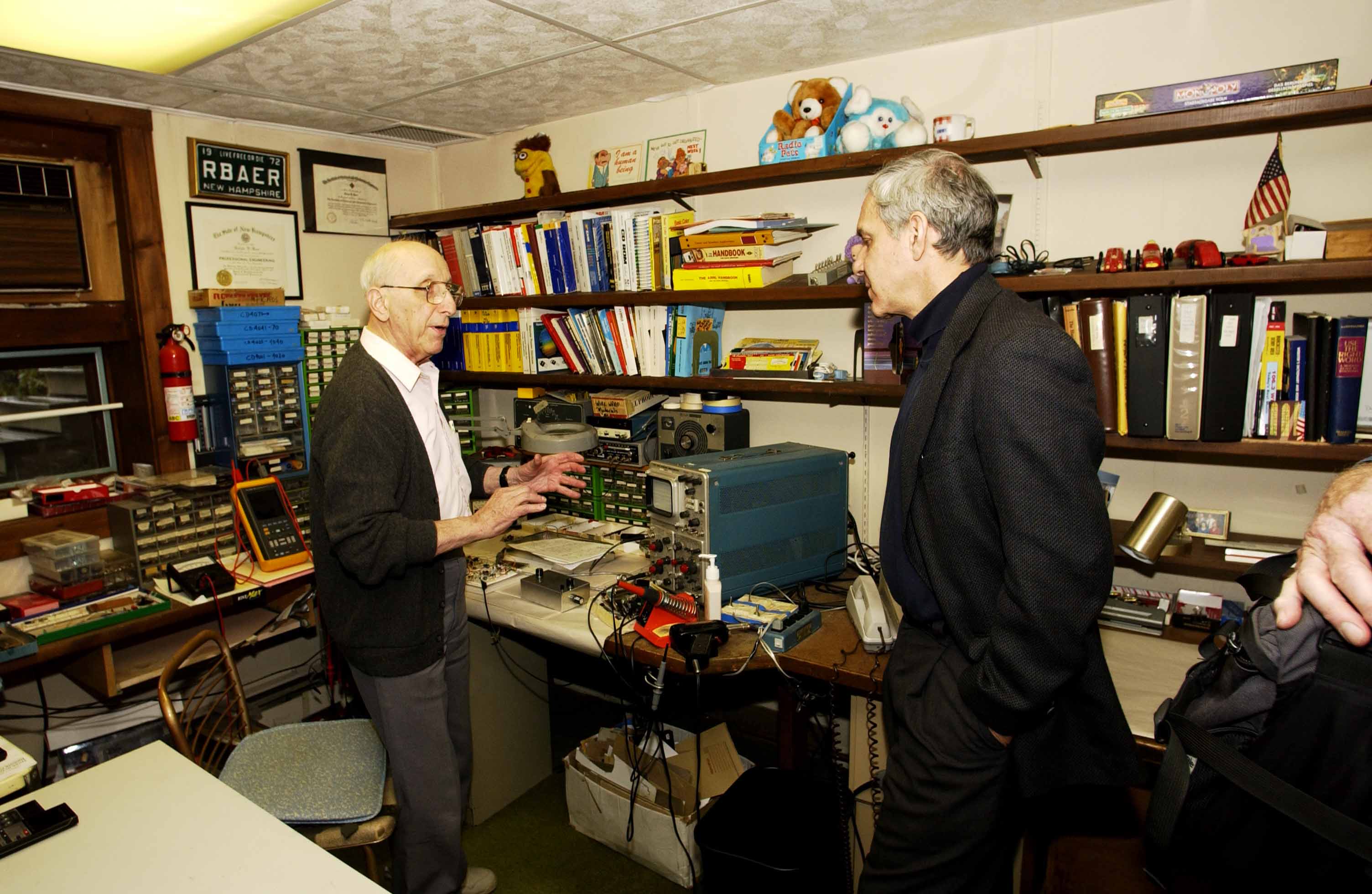 Video game inventor Ralph Baer shows Lemelson Center Director Art Molella his basement workshop.