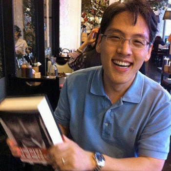 Hyungsub Choi holding a book and smiling broadly