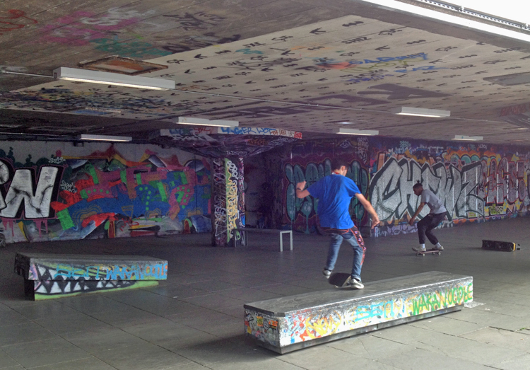 Two skaters in the graffiti-rich Southbank Skate Space under the Southbank Centre in London.