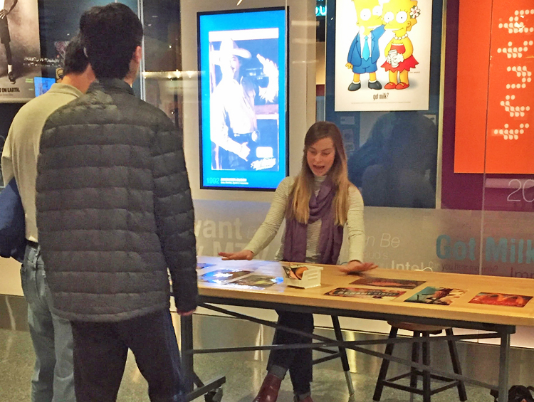 Two visitors engage with museum faciliator at a matching game outside American Enterprise!