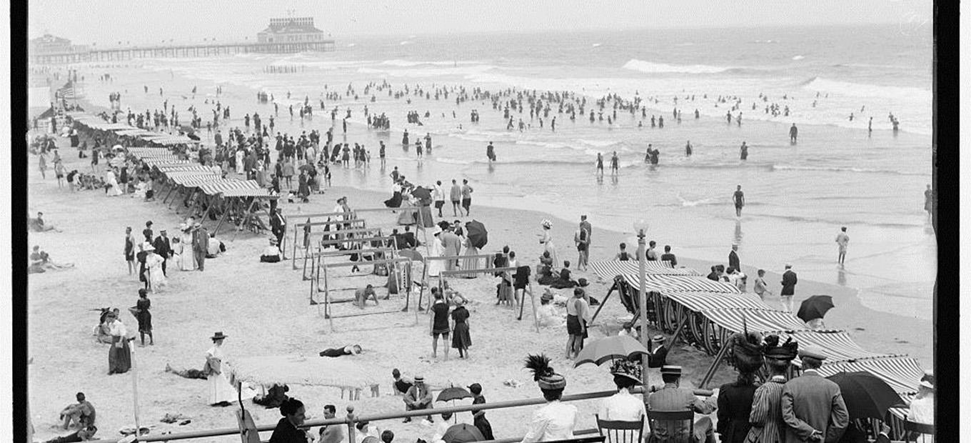 Black and white photograph of crowds on the beach in Atlantic City, NJ in 1908.