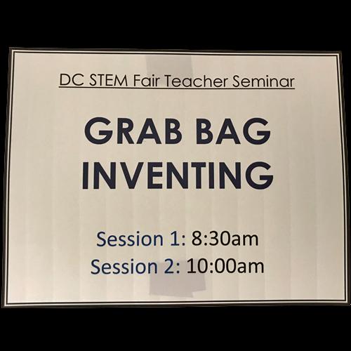 A sign reads CD STEM Fair Teacher Seminar, Grab Bag Inventing, Session 1: 8:30am, Session 2: 10:00am. Black letters on white background.