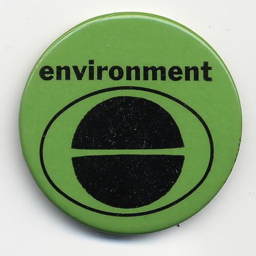 Green metal button with “environment” in black letters above the Earth Day logo