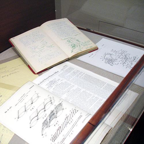 An invention notebook and patents in a display case