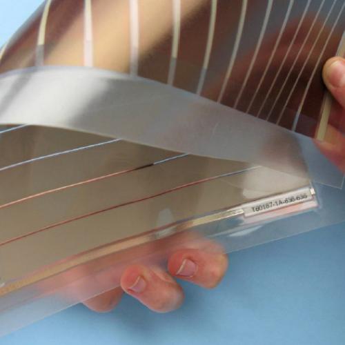 Person's hands bending a flexible thin film solar panel